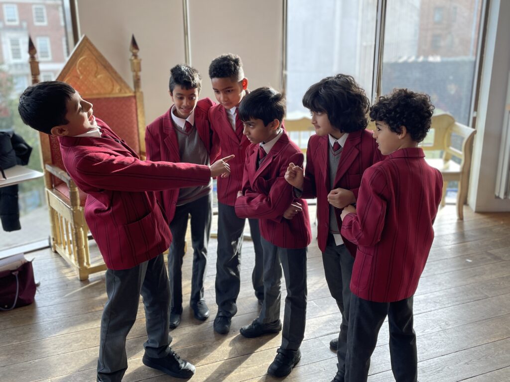 Six schoolchildren acting out a scenario in a light-filled space