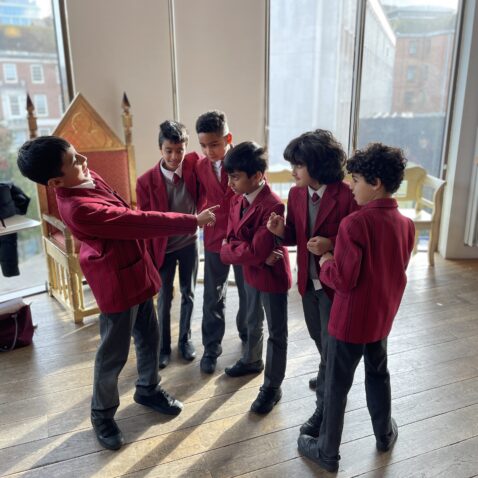 Six schoolchildren acting out a scenario in a light-filled space